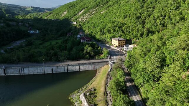 Drone shot of SP21 Vernasca after rockslide on April 22nd 2025, excavators operate to clear blocked road, surrounded by woodland and scattered rocks, real time