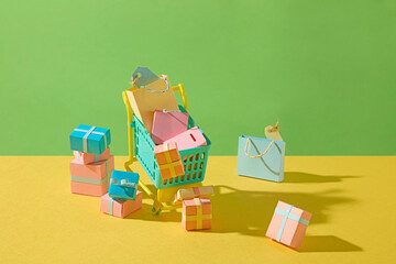 Paper cutout of a shopping cart filled with goods, symbolizing online grocery shopping with...