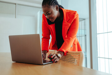 Fototapeta na wymiar Confident professional woman multitasking with technology in a bright office setting