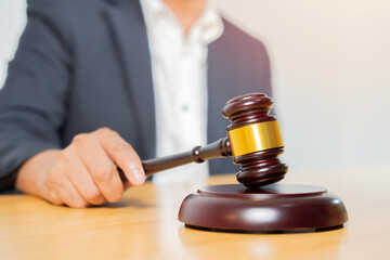 A justice and law concept with a gavel held by a male lawyer, working in the room