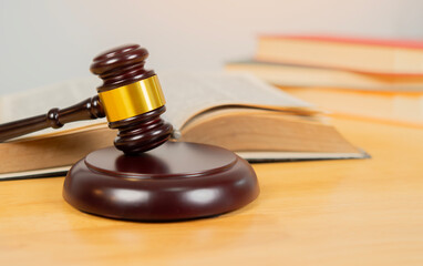 Law and justice. Wooden judge gavel with documents and law books in courtroom
