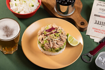 Tinned tuna salad on a plate with beer rice and other snacks in a modern interior, food art