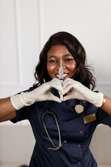 happy woman in dark medical uniform holding syringe in hands