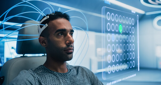 Man Uses a Neural Headset in a Futuristic Lab, Interacting with a Holographic Interface Displaying a Grid of Circles, Man Playing Video Game with His Mind Manipulating Figures