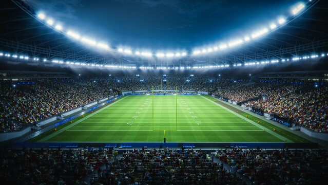 Night View of a Packed American Football Stadium. Thousands of Spectators Fill the Stands Surrounding the Game Field, Ready for a Major Sport Event. Behind the Goal Posts Shot