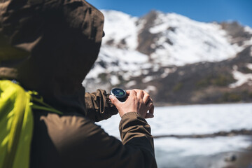 Backpacking woman checking the elevation on sports watch on high altitude mountain top