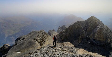 A hiker looking away on the Monte Perdido peak, with the Soum de Ramond in the background, in the Ordesa National Park in Spain