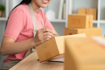 Small Business Efficiency. Entrepreneur smiling while packaging orders.