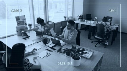 CCTV shot of male and female colleagues discussing documents and reports in modern office, working with financial and business paperwork