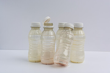 dirty empty plastic bottles from under yogurt on a white background, isolate
