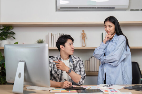 UX and UI Designers Collaborating. A focused discussion about design elements in a modern office.