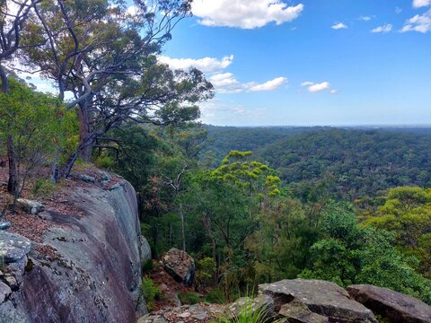 View of green rolling hills and large rocks in the Blue Mountains from Bowen Mountain, Sydney, Australia