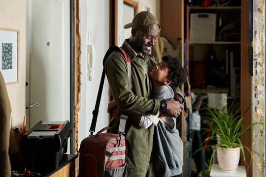 Parent hugging child in a warm home environment before going to work, both expressing joy and comfort