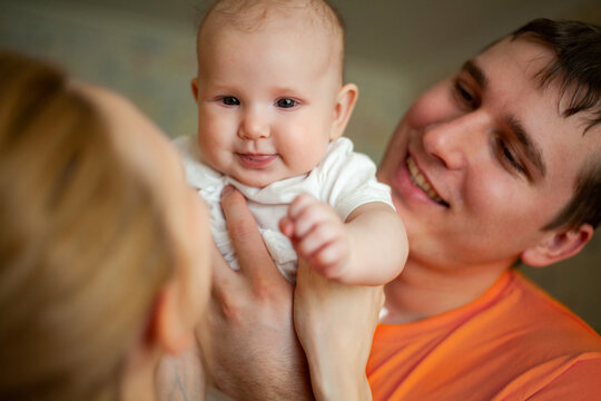 A young married couple tenderly holds their newborn first-born baby