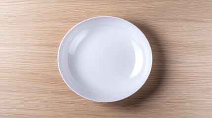An empty white plate on a wooden table.