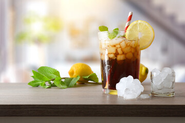 Refreshing cola drink with mint and lemon in living room