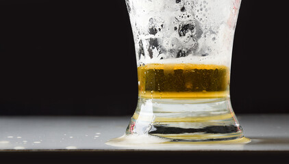 Detail of empty beer glass with foam isolated on black