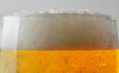 Mouth of a glass of beer with foam isolated background