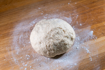 yeast dough on a wooden board. Fresh baked goods. Food. Bread. The concept of food