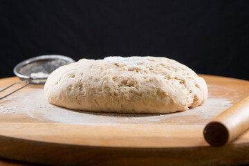yeast dough on a wooden board. Fresh baked goods. Food. Bread. The concept of food