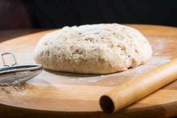 yeast dough on a wooden board. Fresh baked goods. Food. Bread. The concept of food