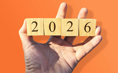 A hand holds wooden blocks arranged to display 