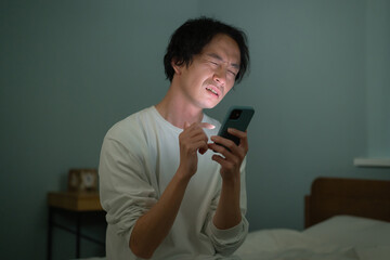 男性　スマートフォン　スマホ　ベッド