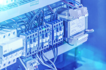 Close-up of an industrial electrical control panel featuring circuit breakers, relays, and wiring...