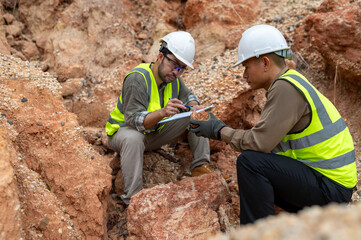 Two geologists are collecting soil samples in a mountain for mineral analysis