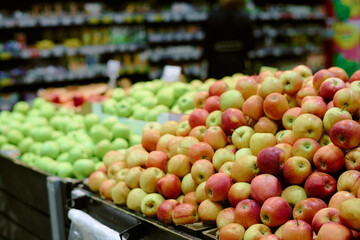 Variety of fresh apples displayed in grocery store aisle, offering vibrant colors and options for...