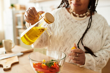Young woman prepares a fresh salad with colorful vegetables at home