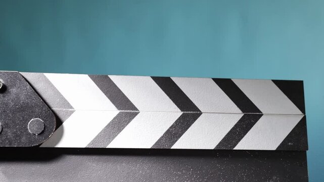 Cinematic production moment, clapperboard snapping shut, creating a dust effect in the studio