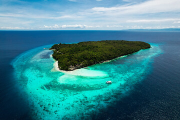 Sumilon Island aerial view, stunning turquoise and deep blue tones surround this remote tropical island with coral reefs and lush mangroves. A paradise from above. © Noa Kaizen