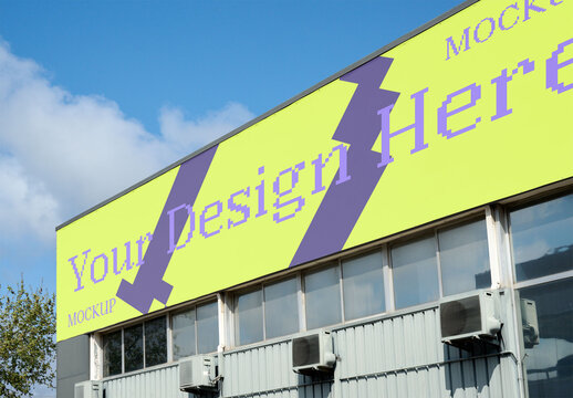 A modern wharehouse with a blank billboard against a blue sky.