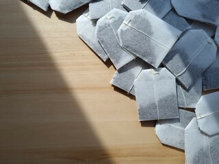 Tea bags on wooden surface. Border of unused tea bags. Unbrewed tea bags on a wooden surface