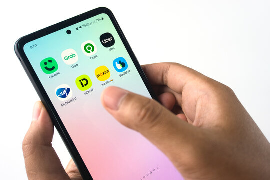 Person Browsing Ridesharing App Icons on Smartphone Screen in Close-Up View. Such as Uber, Grab, Gojek, Careem, inDrive, Bluebird, Maxim, and BlaBlaCar on February 26, 2025 in Sleman, Indonesia