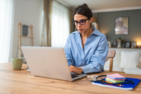 Young woman freelance worker small startup company business owner calculating tax return with data on laptop computer. Working at home office, professional occupation female modern technology user.