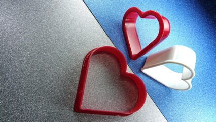 Kształty serc na brokatowym srebrno niebieskim tle © tomo81