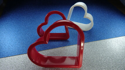 Kształty serc na brokatowym srebrno niebieskim tle © tomo81