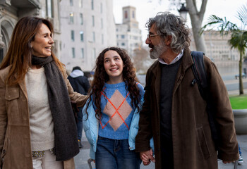 Happy family walking and holding hands in urban setting