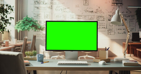Green Screen Monitor in Creative Workspace. Chroma key Display for Video Editing, Virtual Presentations, Marketing, E-business, E-commerce Placeholder. Digital Creativity Environment.