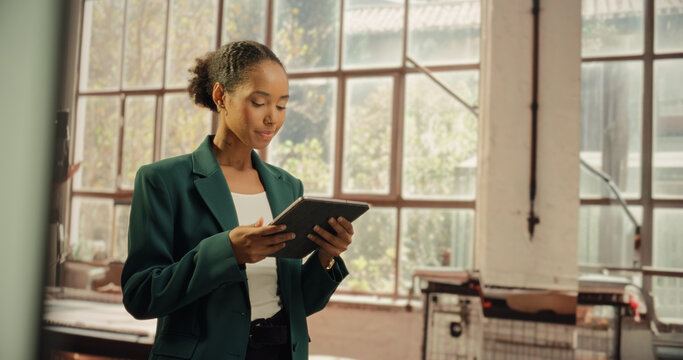 Black Woman Uses Digital Tablet by Sunlit Windows. Creative Empowerd Professional Does Digital Marketing, Modern Workplace Efficiency and Technological Advancement. Portrait of Beautiful Female