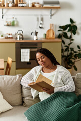 Quiet morning of relaxation for a young african american woman at home with a book