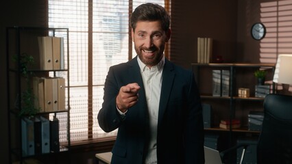Happy smiling man male recruiter mature businessman index finger hey you gesture pointing at wrist like wristwatch showing time late invite join business team office inviting come here welcome hiring