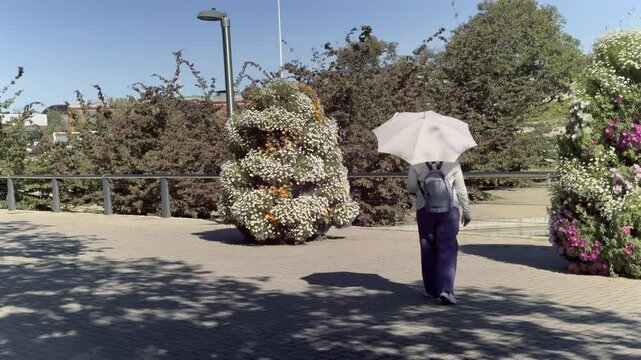 Woman with Umbrella Walking in Rosaleda Juan Carlos I Park
