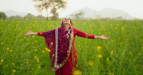 Indian adult gen x beautiful model woman lady wear red traditional saree enjoy outdoor nature Asian...