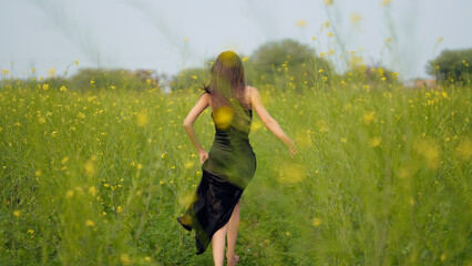 Indian happy young adult gen z model lady woman wear black dress outdoor garden enjoy nature Asian...