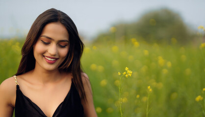 close up of Indian happy young adult gen z beautiful model woman lady wear black dress standing...