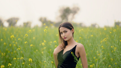Indian happy young adult gen z model lady woman wear black dress outdoor garden enjoy nature spend...
