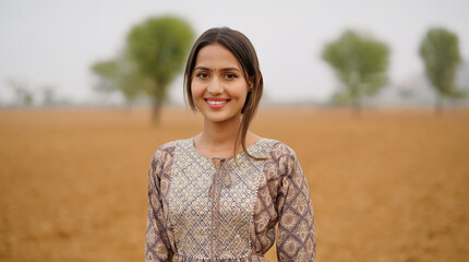 Indian young adult gen z farmer woman wear casual dress outdoor farmland looking at camera Asian...